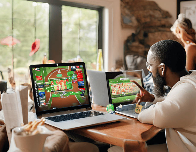 Inside a cozy home, trusted lottery sites are open on a laptop, while nearby, sports betting enthusiasts discuss strategies, creating a contrasting scene of leisure and anticipation.